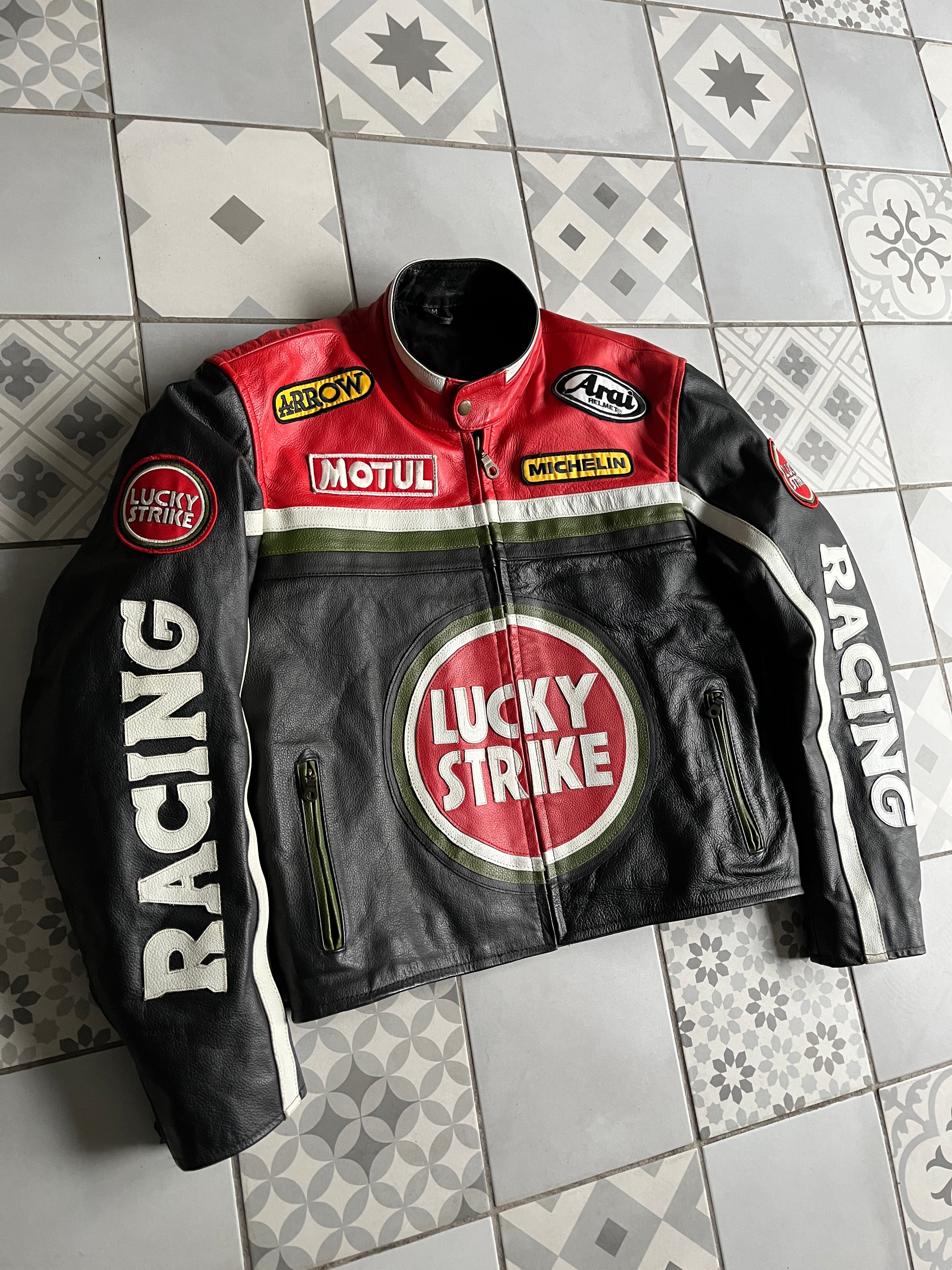 Vue de face complète du blouson moto vintage Lucky Strike en cuir noir et rouge, avec logos sponsors Motul, Michelin, Arai et Arrow