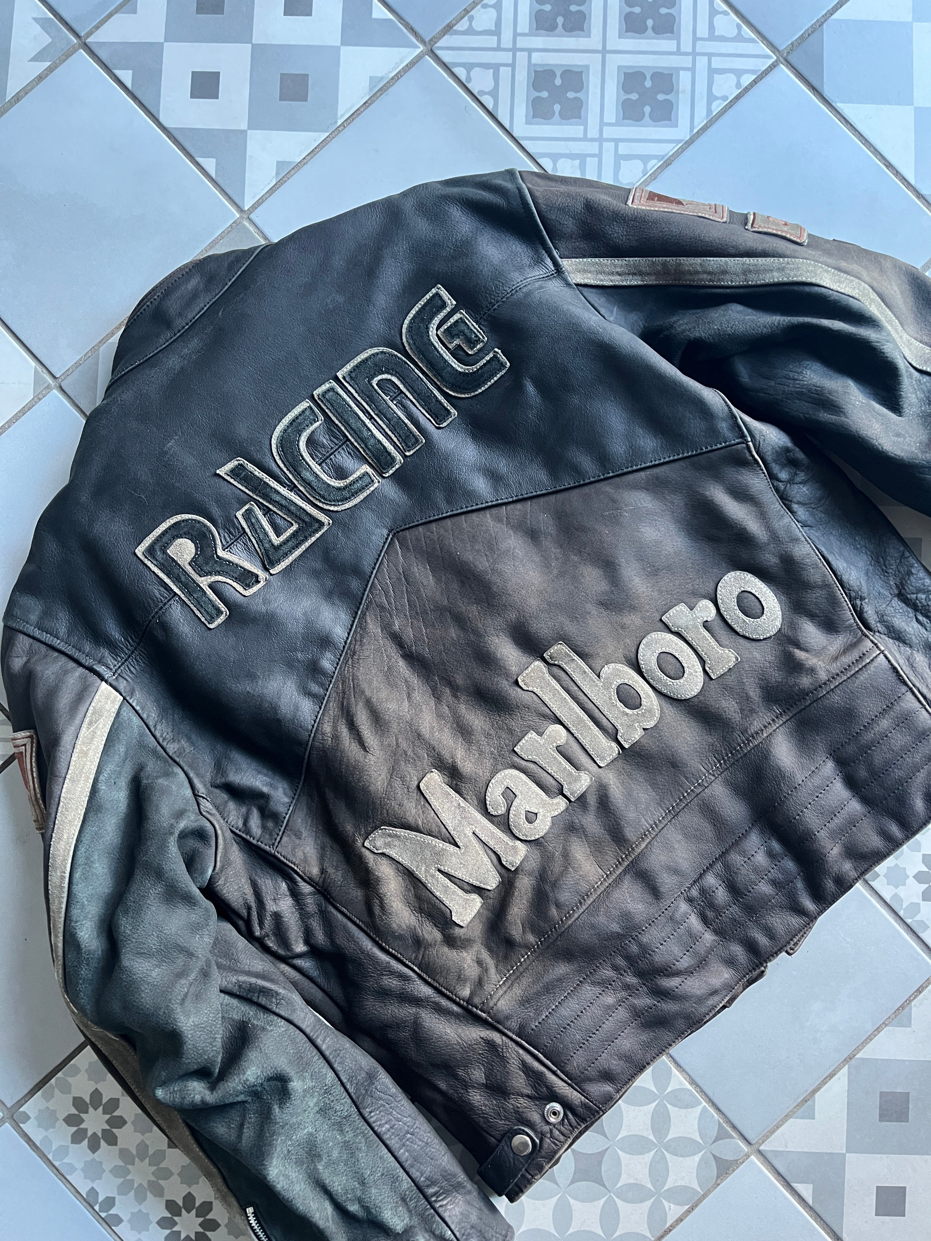 Zoom plongeant sur le dos de la veste : détail des surpiqûres épaisses et du lettrage Racing texturé