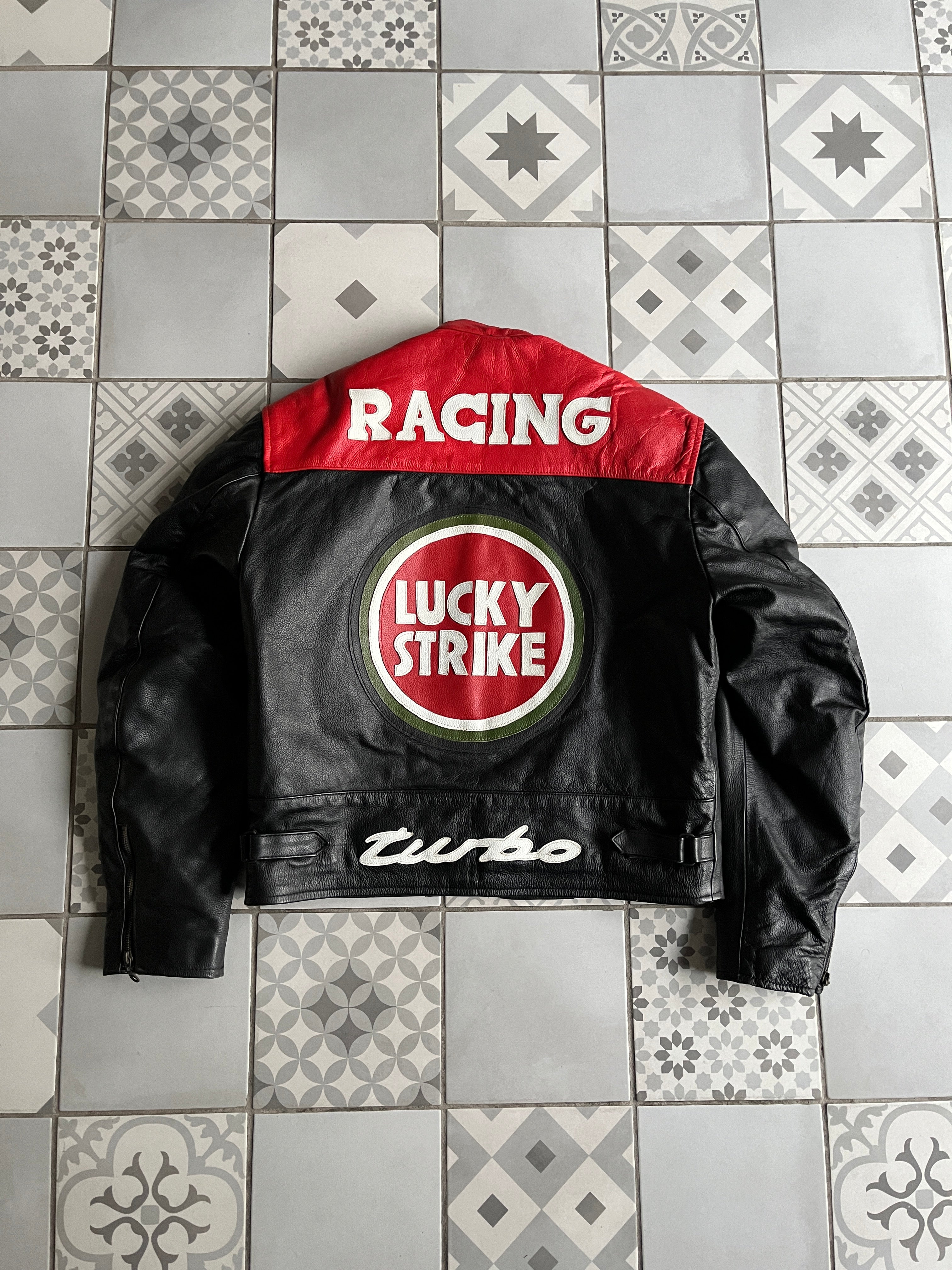 Dos complet du blouson cuir Lucky Strike avec grand logo cible, lettrage RACING sur les épaules et broderie Turbo en bas