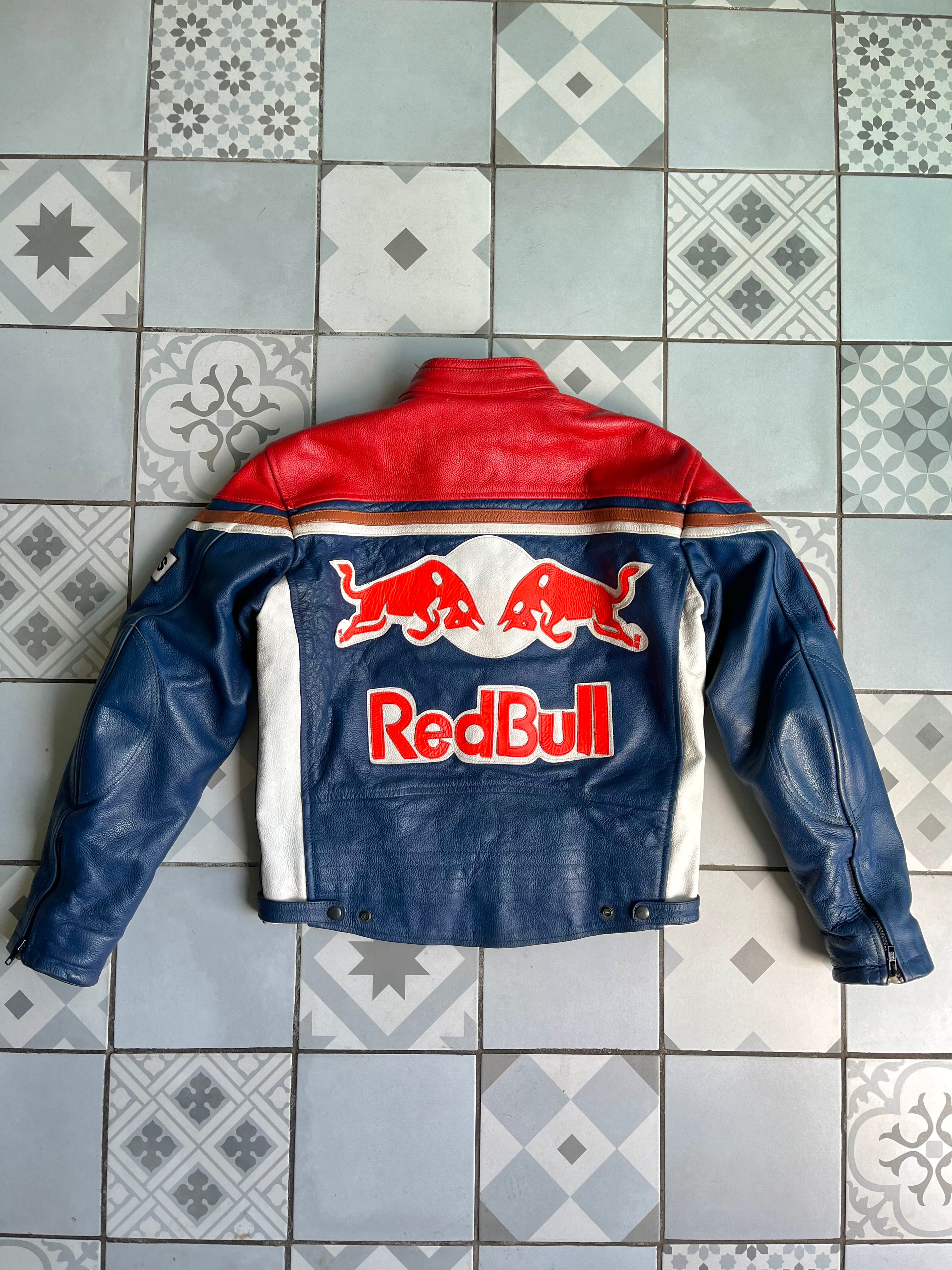 Dos du blouson vintage Red Bull mettant en avant l'immense logo brodé des deux taureaux et le lettrage Red Bull sur fond bleu.