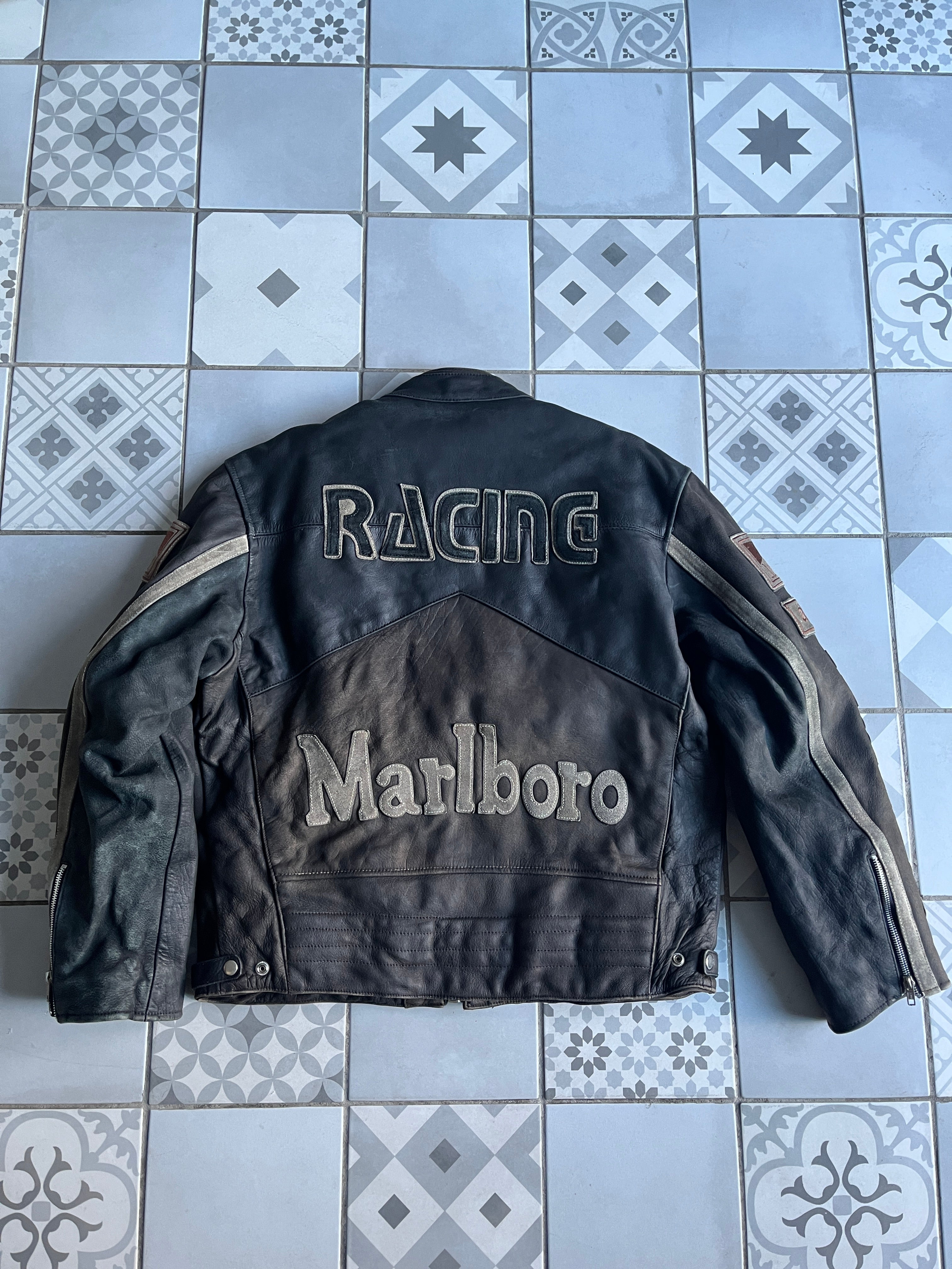 Dos complet du blouson en cuir vintage montrant les grands lettrages brodés RACING en haut et MARLBORO en bas sur un cuir usé