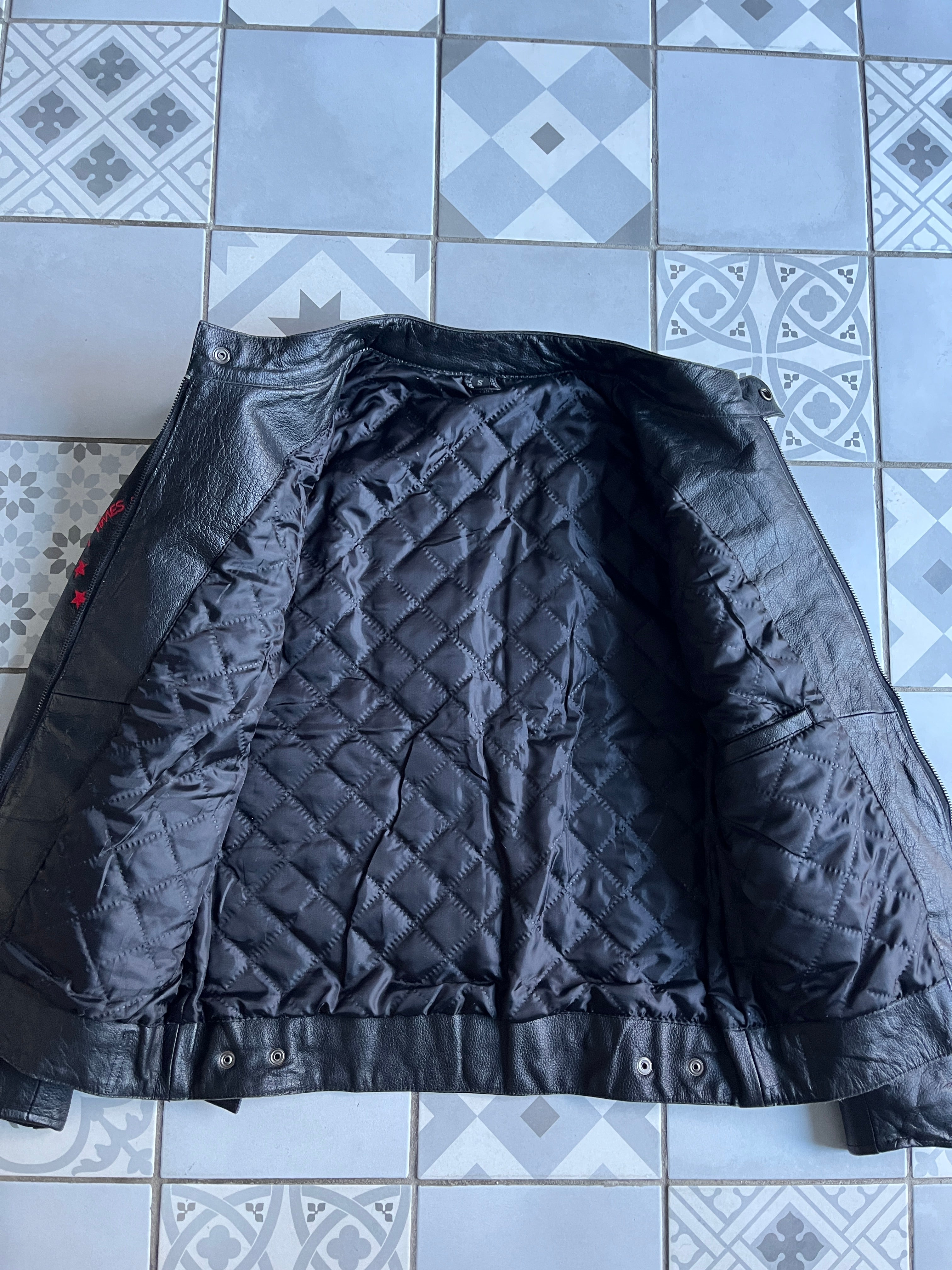 Vue de la doublure intérieure matelassée noire en losanges du blouson cuir vintage, montrant la qualité des finitions.