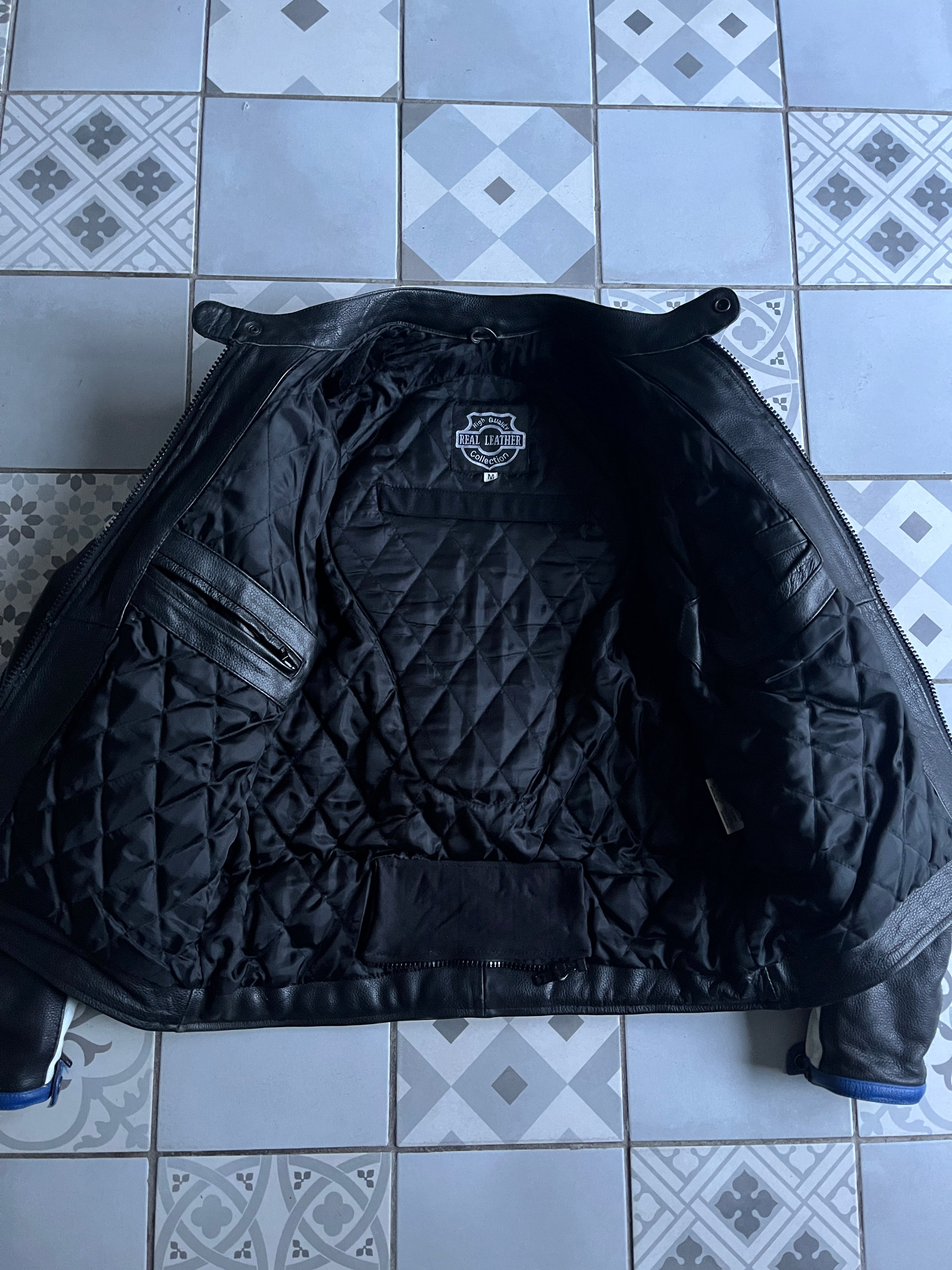 Vue de la doublure intérieure matelassée noire du blouson moto, avec poche portefeuille et étiquette d'authenticité Real Leather Collection.